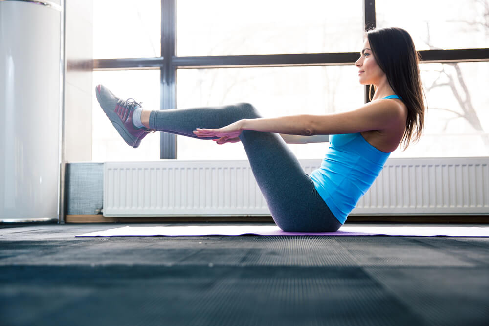 young-woman-doing-exercise-on-yoga-mat-at-gym