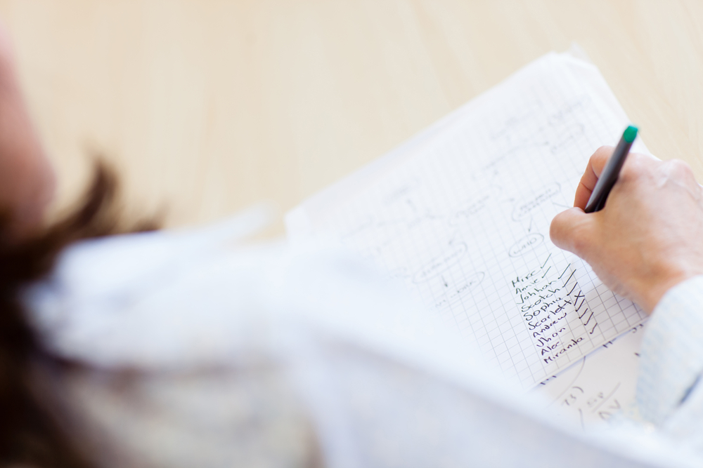 teacher-with-attendance-list-ticking-names-of-students